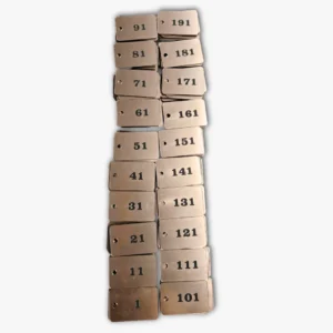 Numeruoti pakabukai iš metalizuoto plastiko su graviravimu.